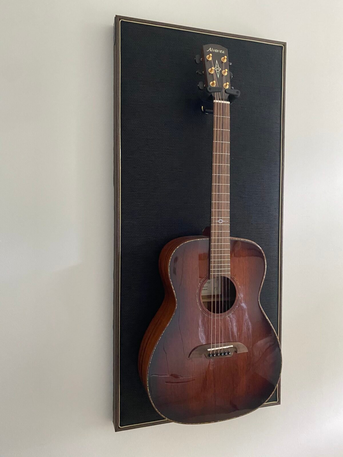 Gitaar aan haak op akoestisch paneel