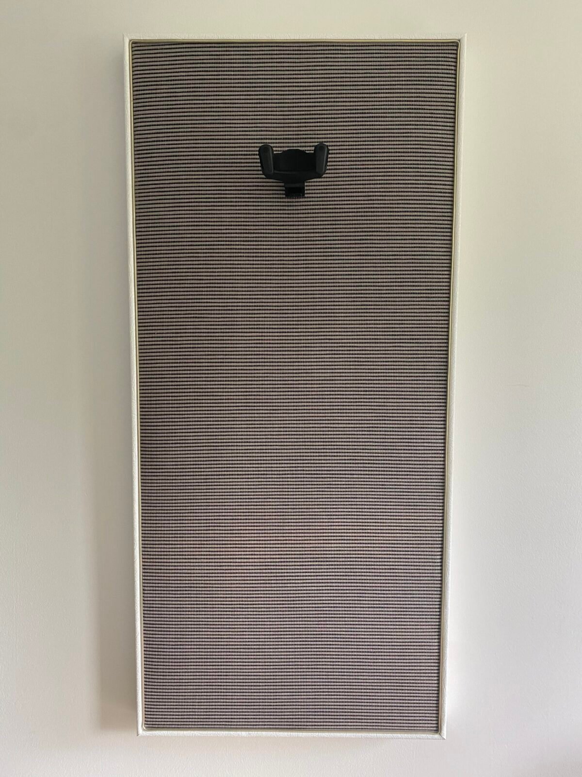 Gitaar aan haak op akoestisch paneel