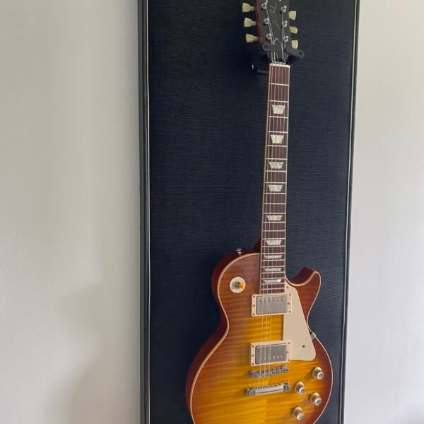 Gitaar aan haak op akoestisch paneel