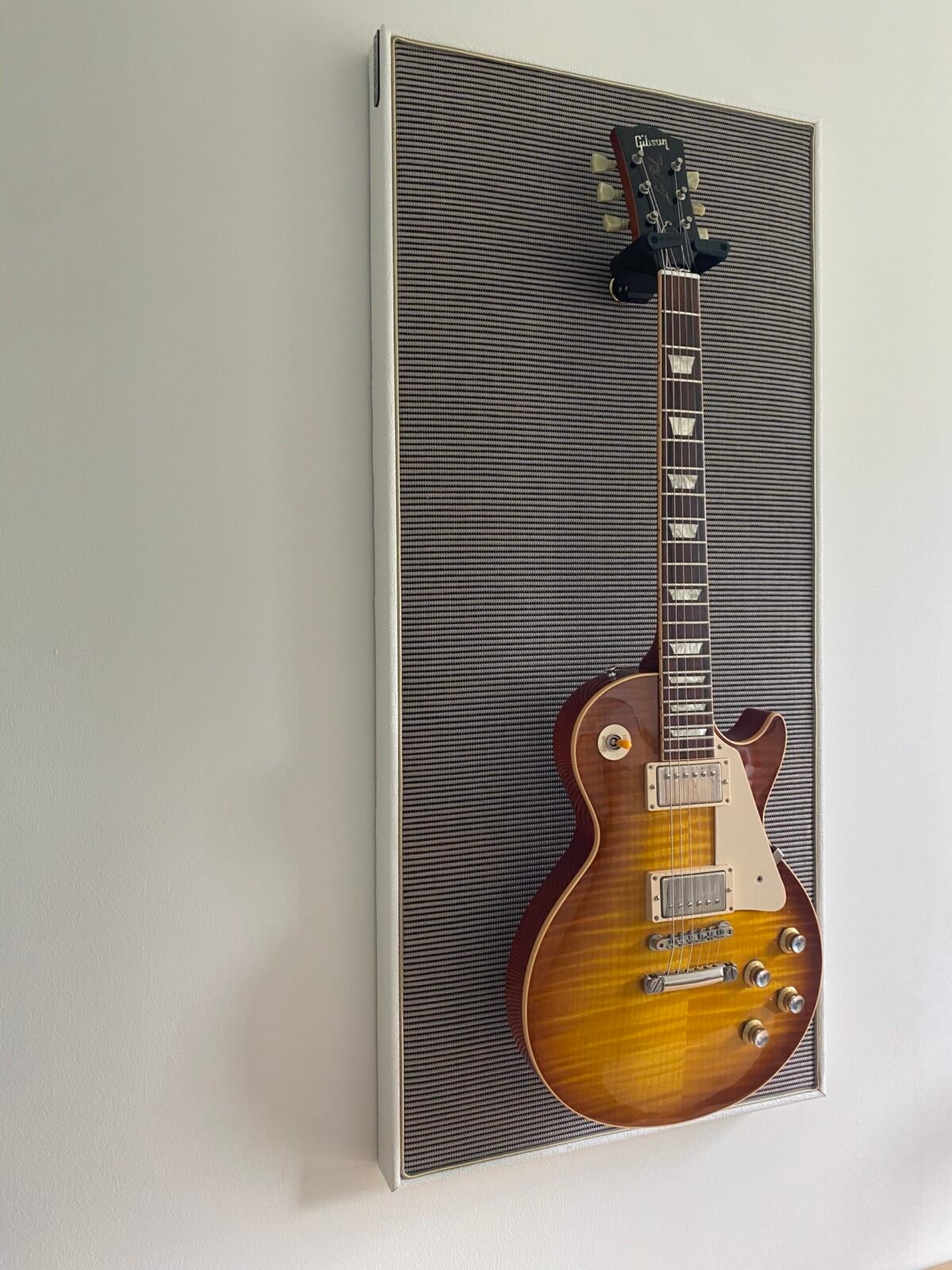 Gitaar aan haak op akoestisch paneel