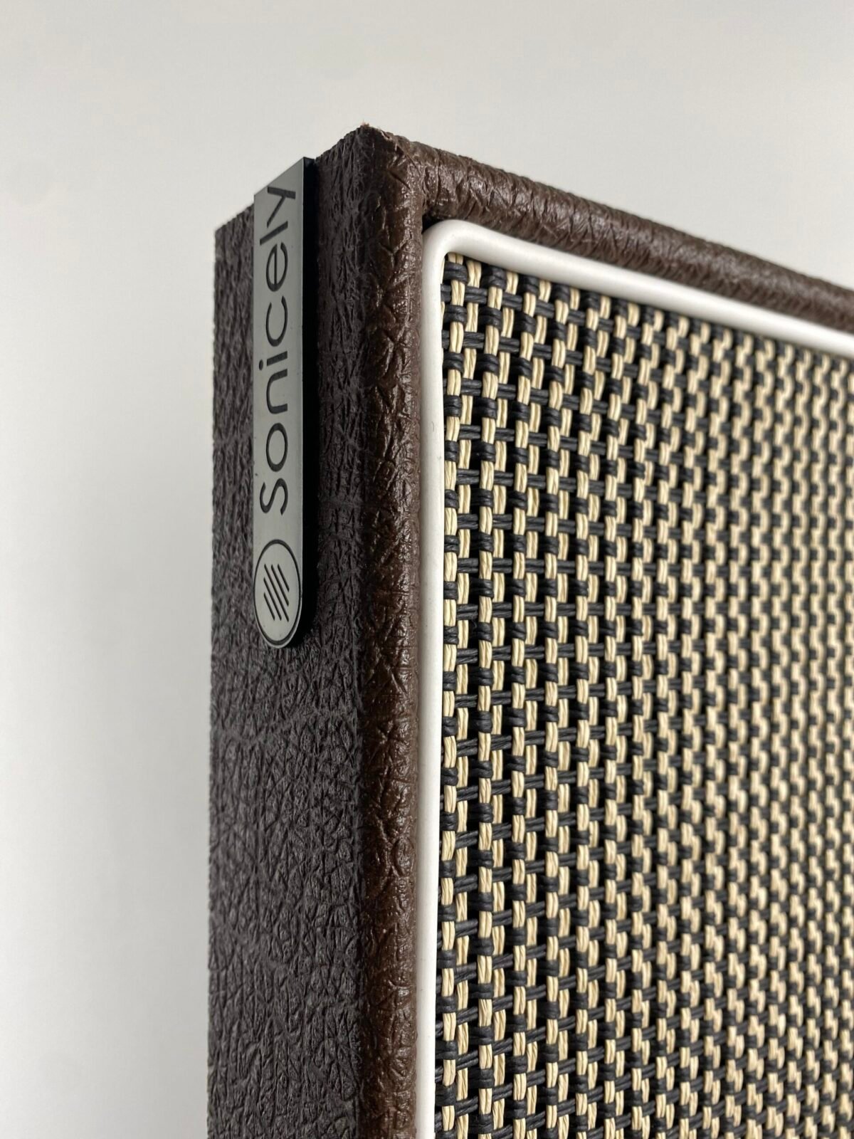 logo Sonicely met salt & pepper speakerdoek op akoestisch paneel