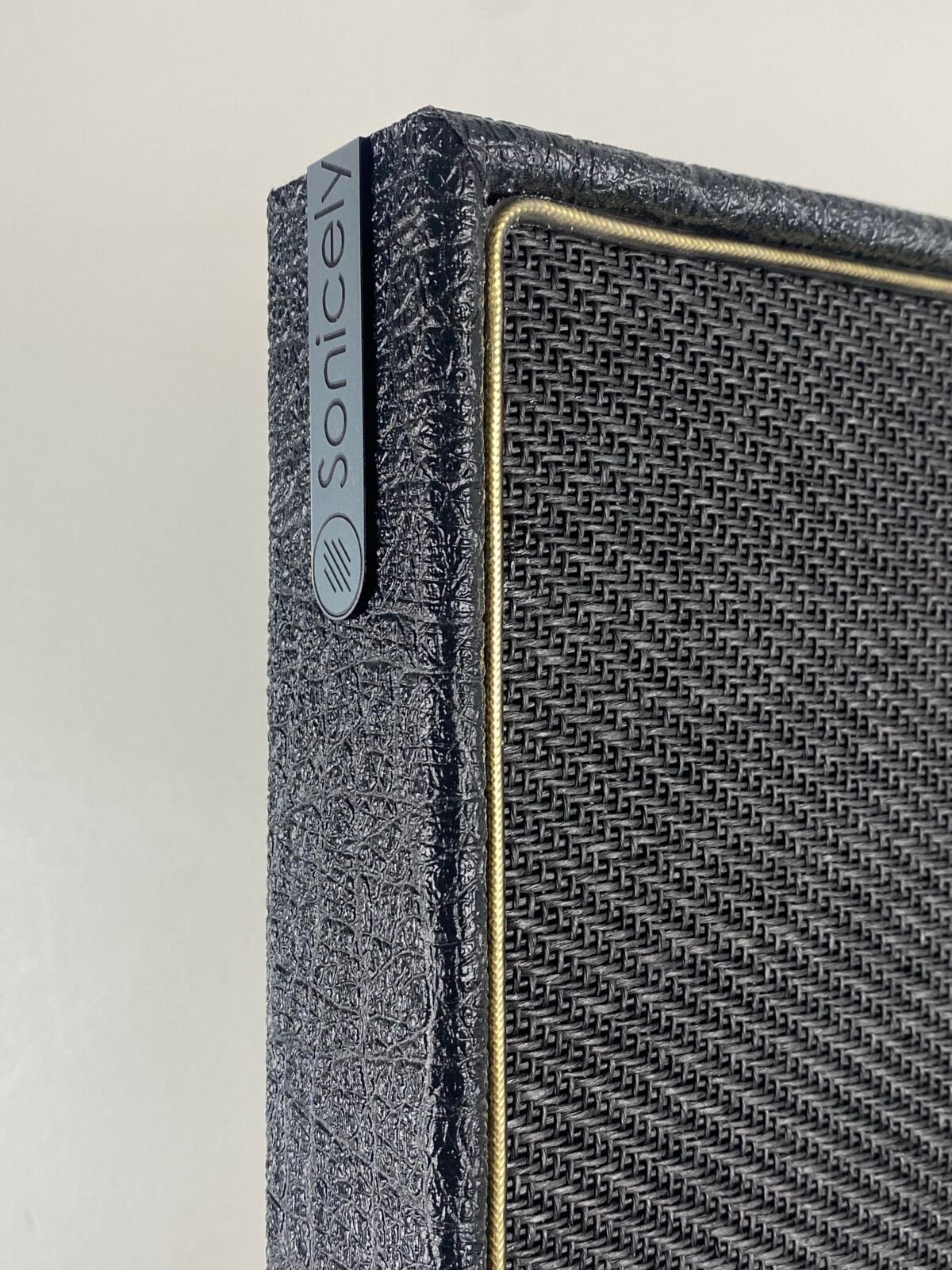 Hoek van zwart akoestisch paneel met gouden bies